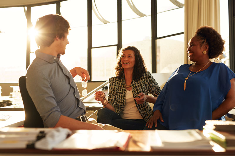 A business group chatting in a sunny office