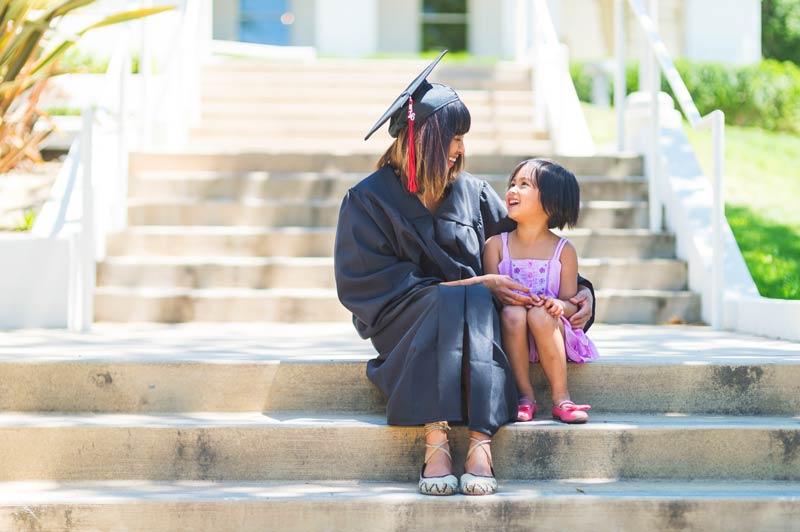 Graduate in her gown with her young daughter
