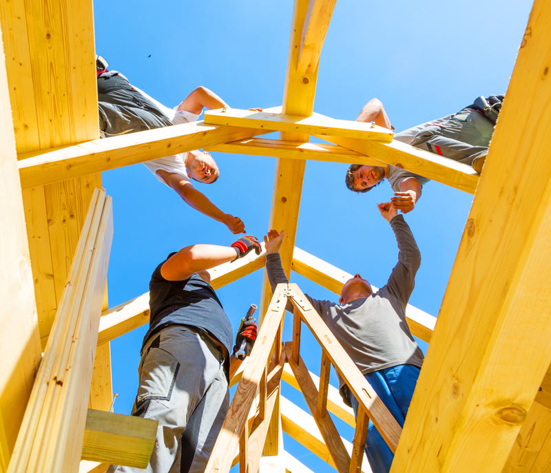 Volunteers building the roof of a house