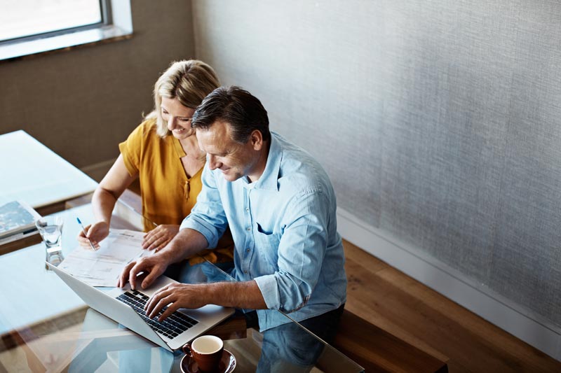 Wife and husband paying bills at their computer